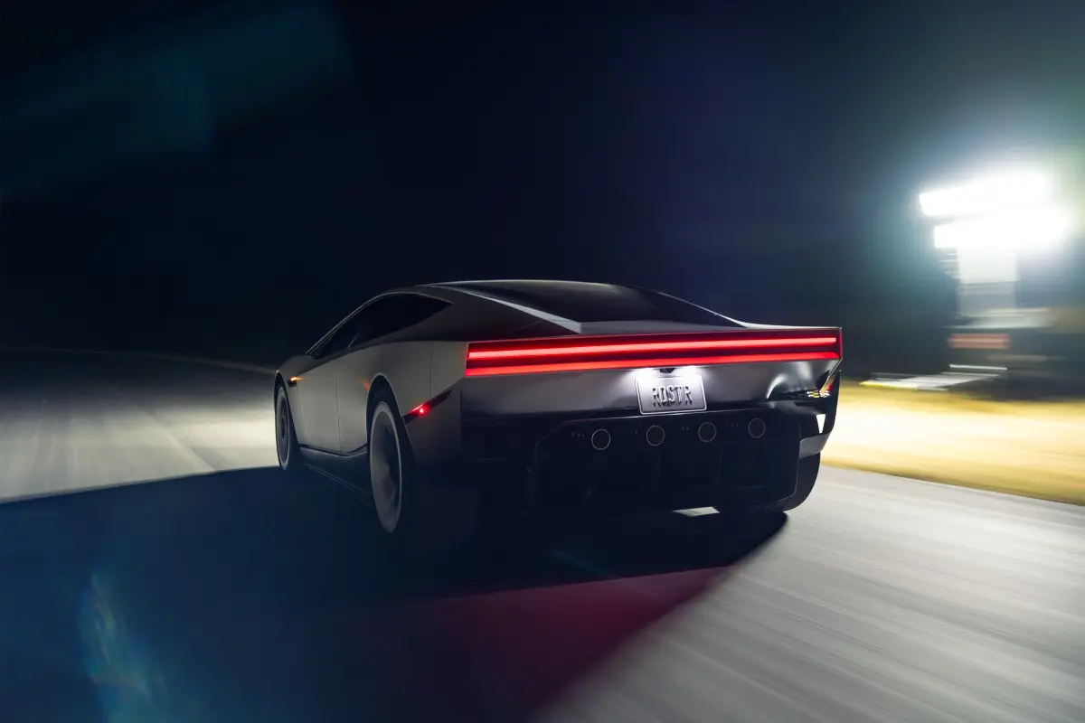 Tesla Roadster de frente, fundo negro, luzes acesas