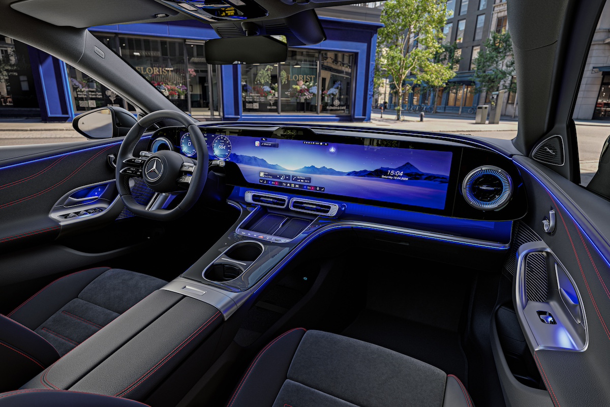 Interior do Mercedes Classe C elétrico com ecrã panorâmico e iluminação ambiente azul