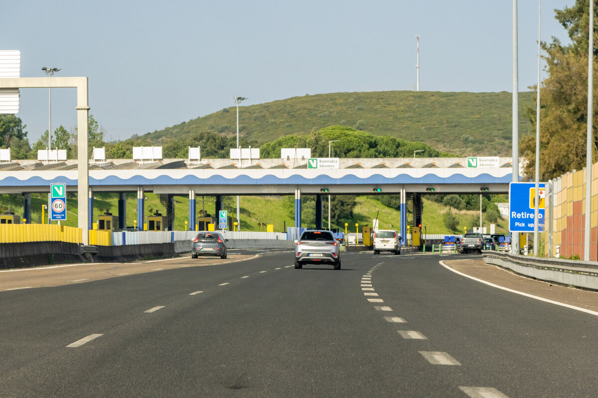 Trânsito em zona de portagem, ilustrando a circulação rodoviária abrangida pelas novas medidas de fiscalização