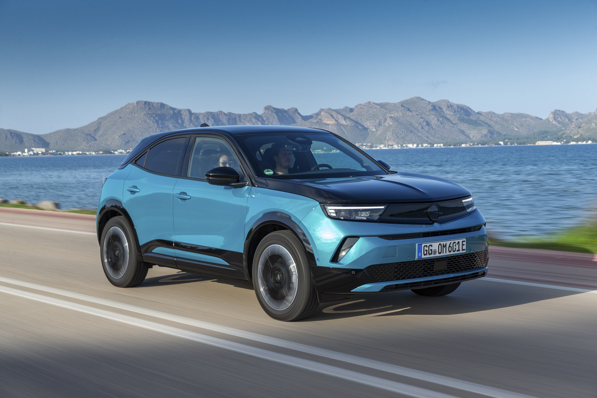 Opel Astra com cabo V2L ligado a dispositivo externo, num ambiente ao ar livre