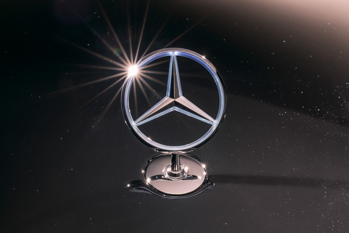 Vista exterior de uma fábrica Mercedes-Benz com operários na linha de produção, ilustrando o contexto industrial da reestruturação