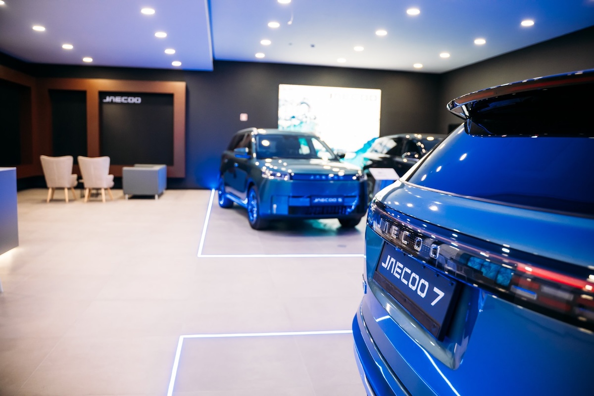 interior de showroom com modelos OMODA 5 e JAECOO 7 em exposição