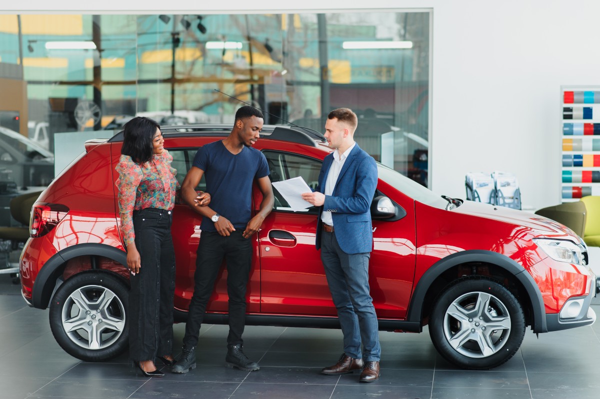 comprador a inspecionar um carro usado num particular, prestando atenção à carroçaria e ao habitáculo