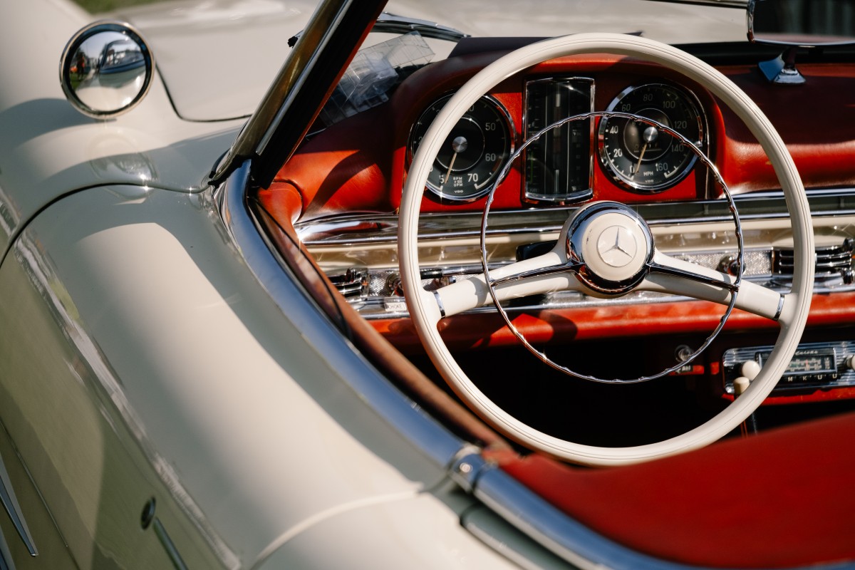 Detalhe do painel de instrumentos ou do motor de um automóvel clássico dos anos 1990, em ambiente de garagem, ilustrando conservação e manutenção cuidada
