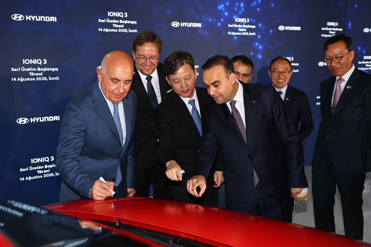 Hyundai IONIQ 3 estacionado numa zona urbana europeia, com tomada de carregamento visível e ambiente citadino ao fundo