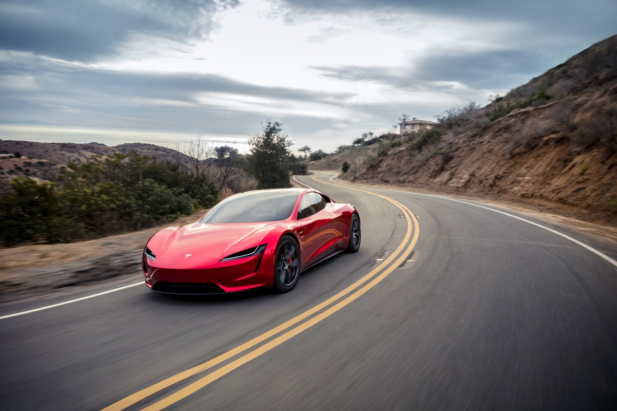 Tesla Roadster segunda geração em estúdio, vista lateral sobre fundo escuro, destacando o perfil aerodinâmico do cupé eléctrico
