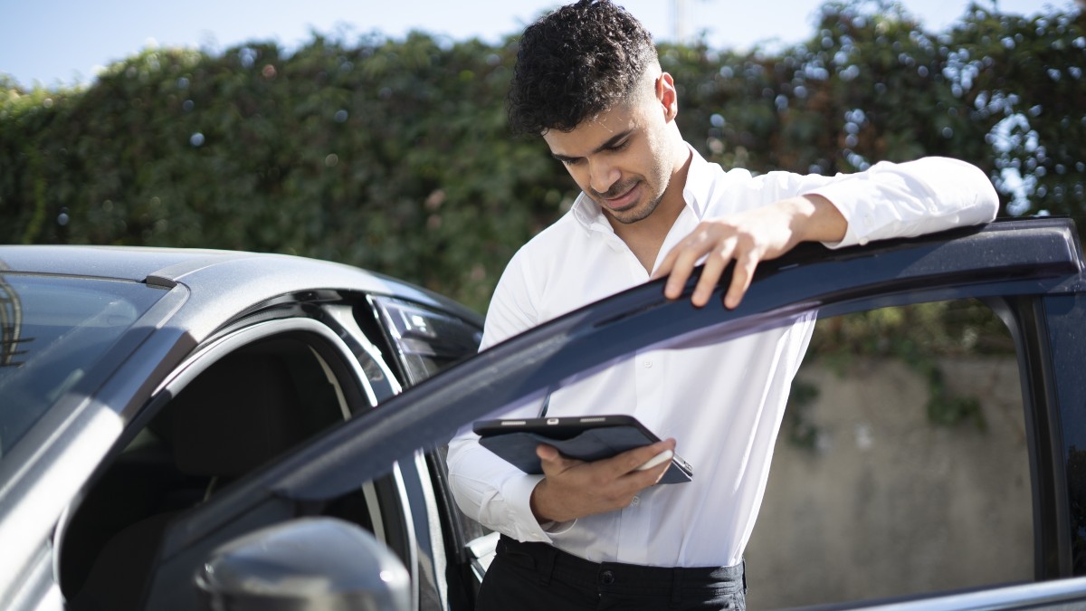 Comprador a realizar test drive num carro usado, ao volante, numa estrada ou parque de estacionamento