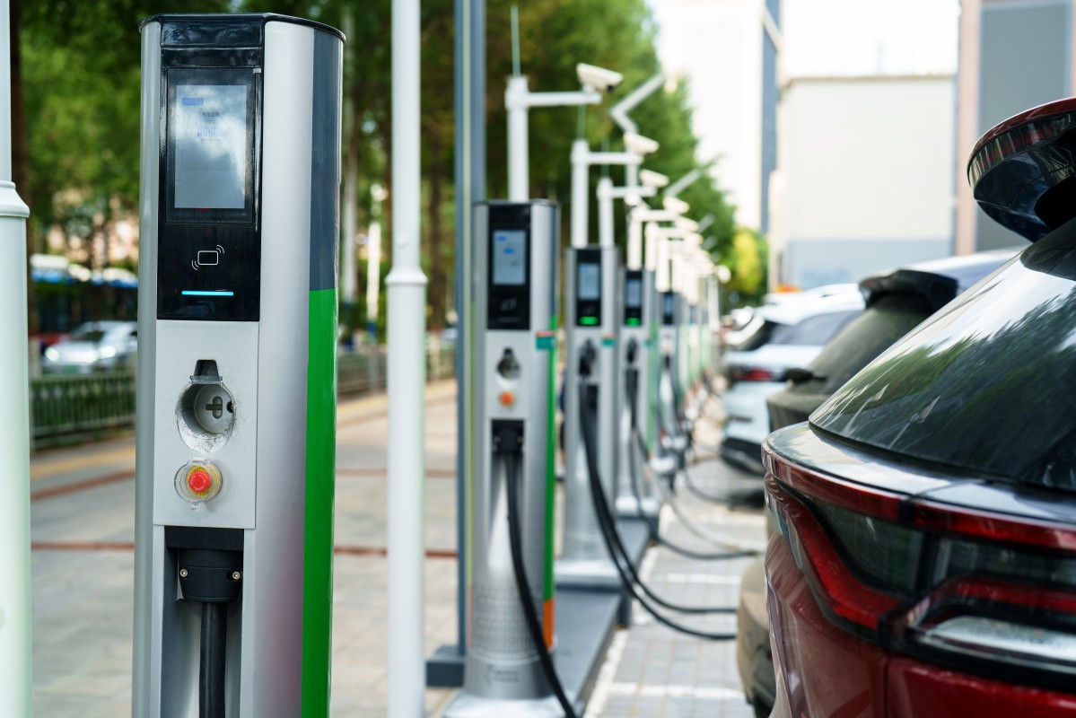 Carro eléctrico ligado a um carregador doméstico durante a noite, ilustrando boas práticas de carregamento